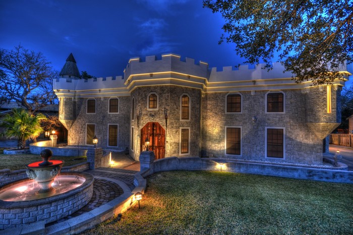 Castle-style house with fountain at night
