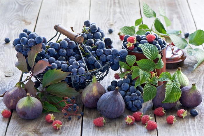 Grapes, Figs, Raspberries, and Blueberries on a Wooden Table