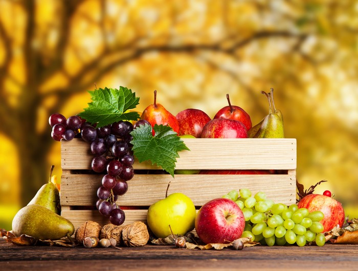 Fruit in a wooden crate with autumn background