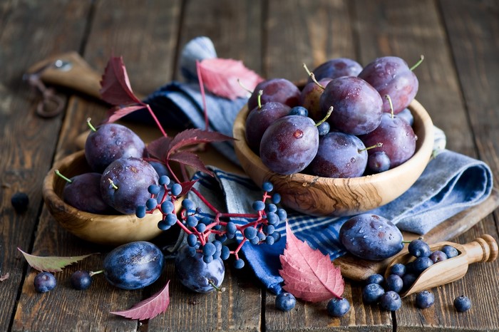 Plums and blueberries on wooden table