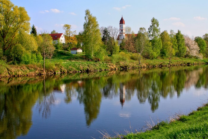 River reflecting trees and a church in Germany
