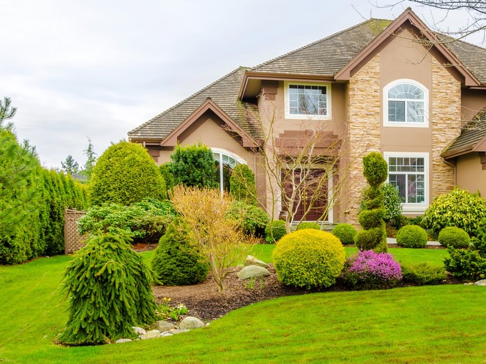 House with manicured landscaping and lawn