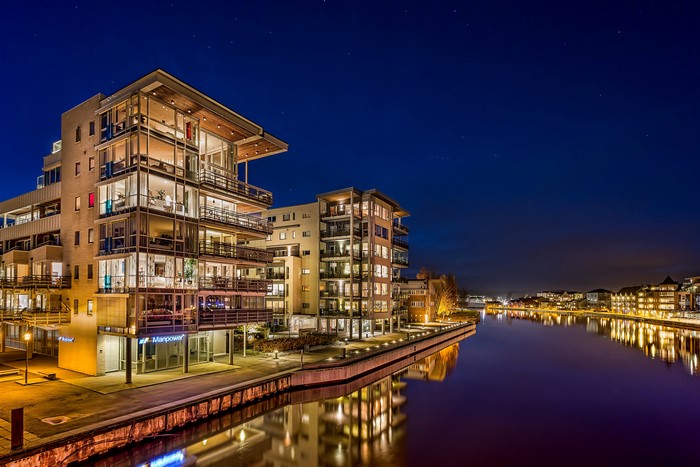 Apartment buildings by a river at night in Fredrikstad, Norway