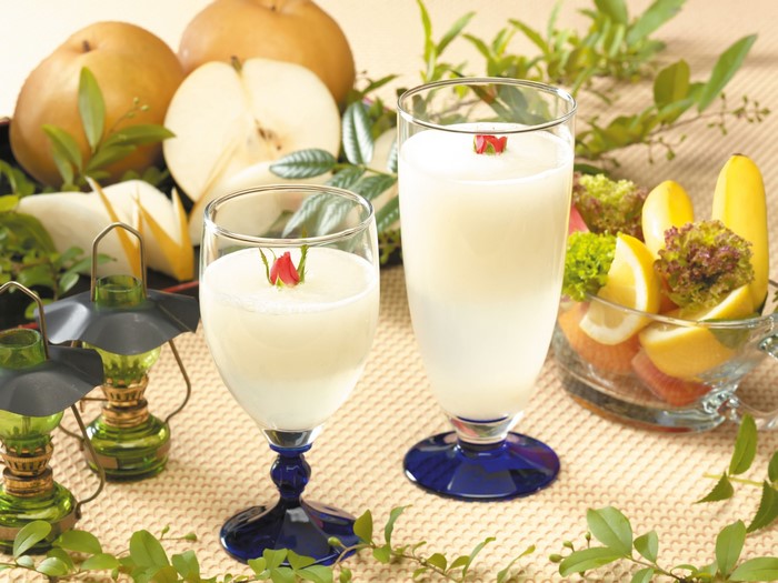 Two glasses of pear juice with pears and fruit salad