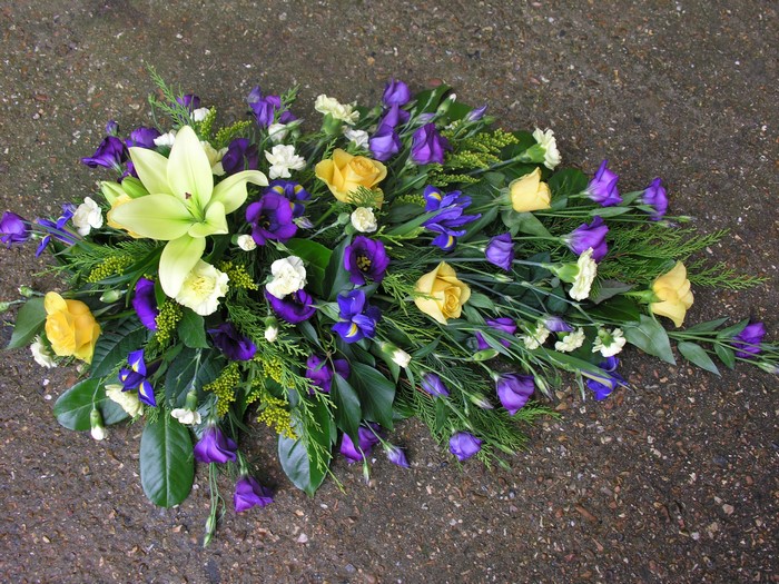Funeral spray of lilies, roses, eustoma, and irises