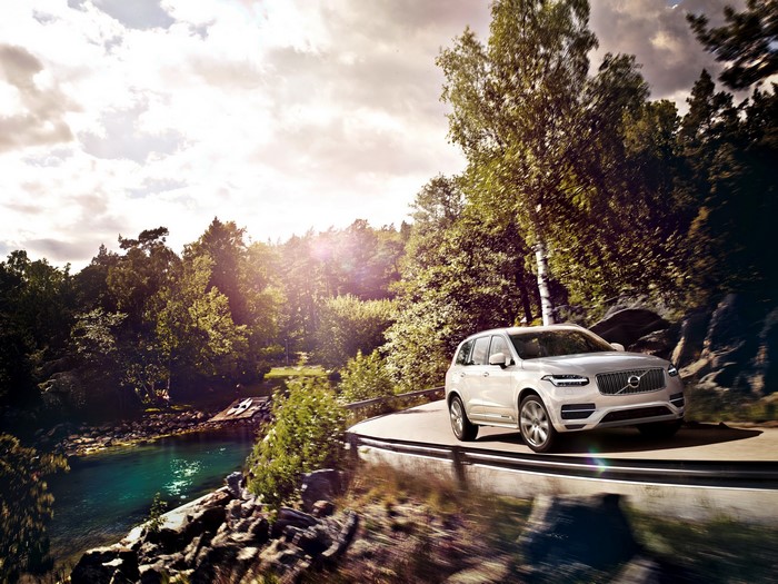 White Volvo XC90 driving on a scenic road