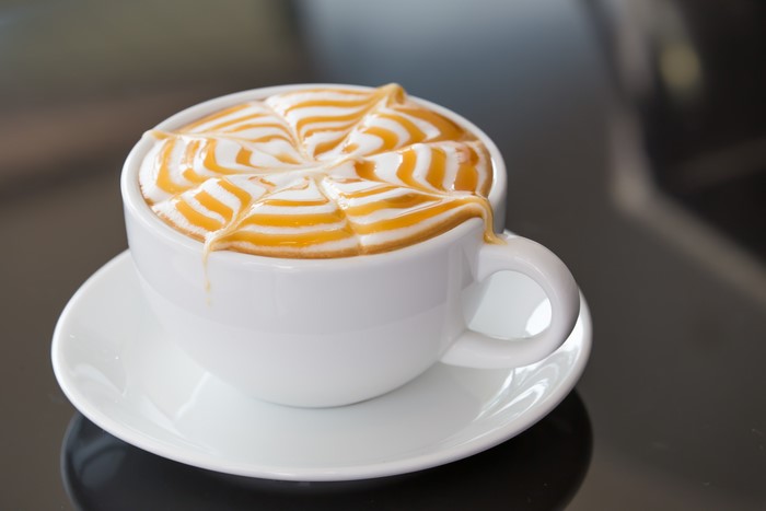 Latte art coffee in a white cup and saucer