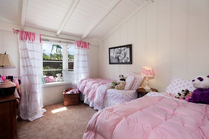 Children's bedroom with two pink beds and curtains