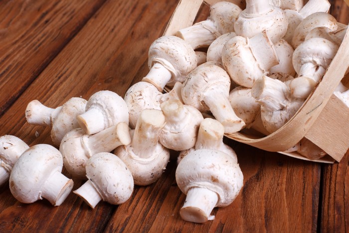 Many White Champignon Mushrooms in a Basket