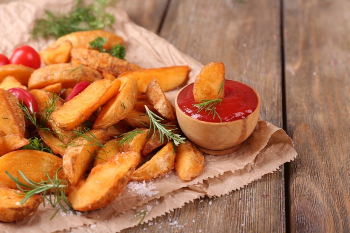 Potato wedges with ketchup and herbs