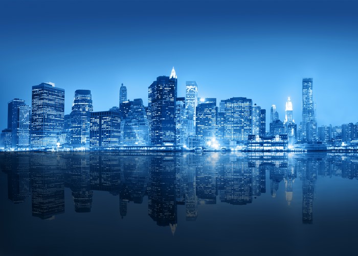 New York City skyline at night with river reflection