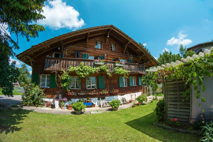 Wooden house with balcony and flowers in Wattenwil, Switzerland