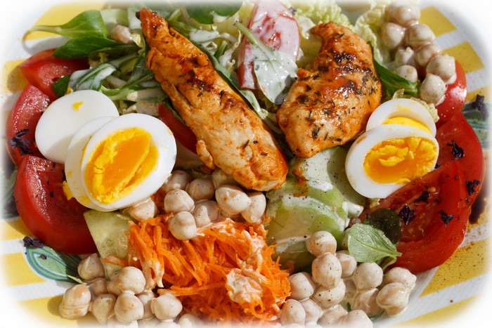 Salad with grilled chicken, eggs, tomatoes, and chickpeas