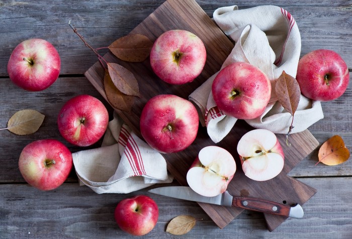 Apples and a knife on a wooden table