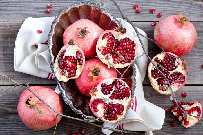 Pomegranates in a bowl on a wooden table