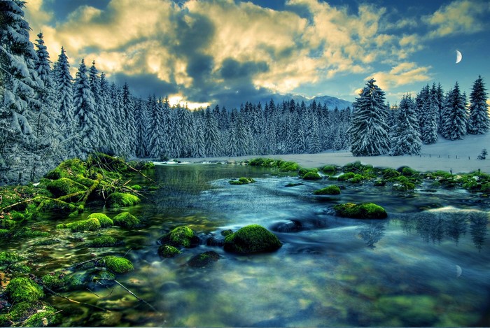 Winter river flowing through a snow-covered forest with mossy rocks