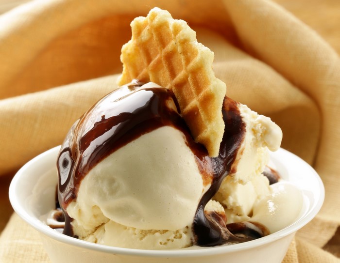 Vanilla ice cream with chocolate syrup and waffle cookie
