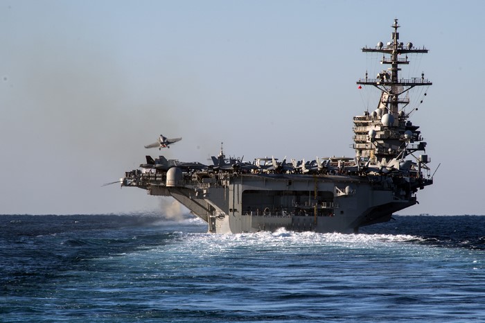 Aircraft carrier launching a jet into the sky