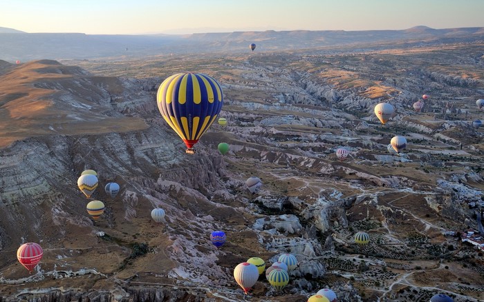 Hot air balloons flying over Cappadocia landscape