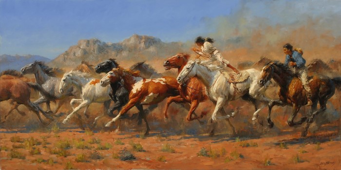 Native American riders on horses in a desert landscape