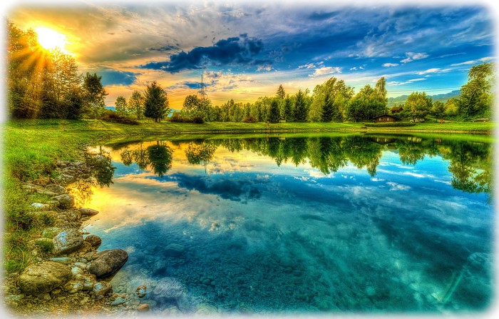 Lake reflection with sun rays and trees