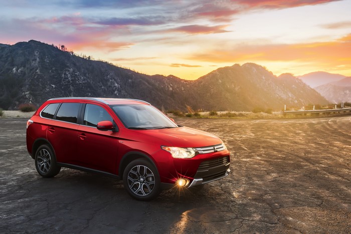 Red Mitsubishi Outlander GT parked at sunset