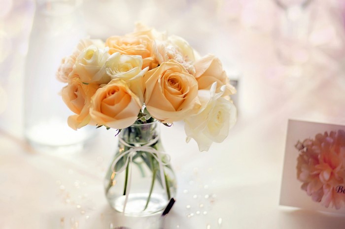 Peach and cream roses in a glass vase