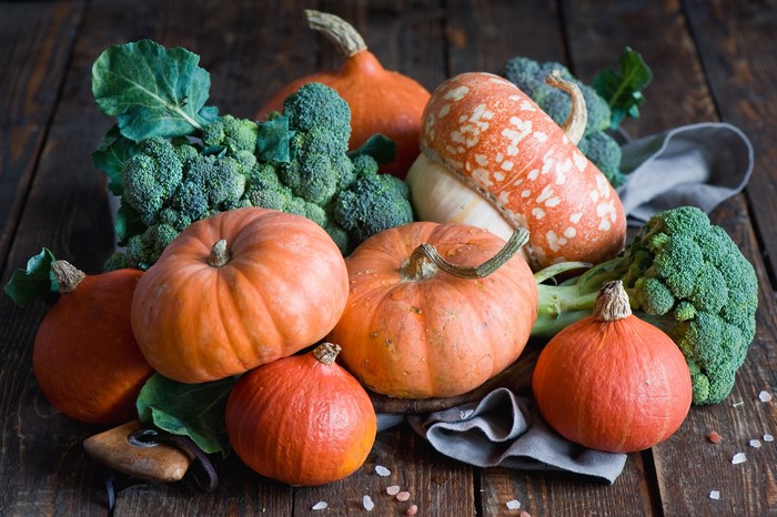 Pumpkins and broccoli on a wooden table