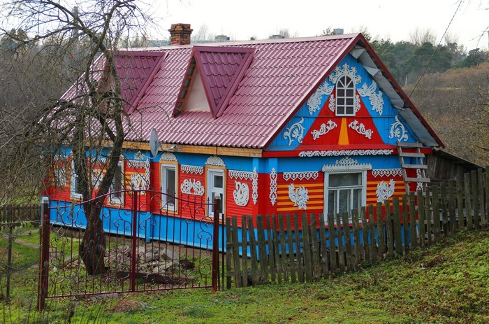 Colorful Russian house with ornate wooden carvings and fence