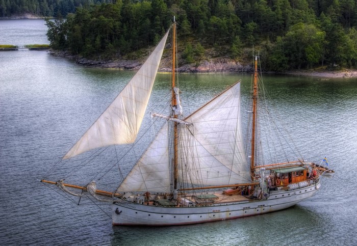 Sailing ship on a lake with forest background