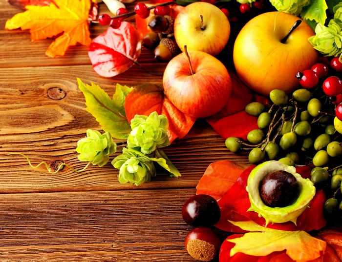 Autumn harvest with apples, grapes, and leaves