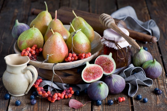 Pears, Figs, Blueberries, and Honey Jar on Wooden Table
