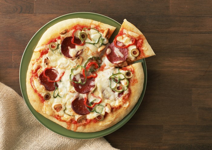 Pizza with pepperoni, peppers, and olives on a plate