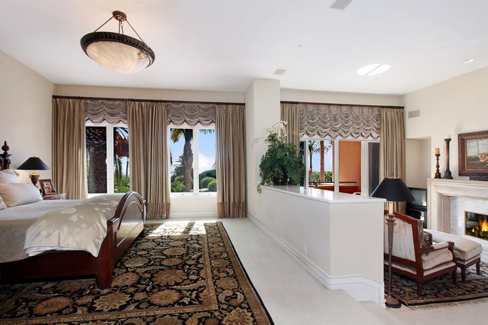 Bedroom with bed, carpet, lamp, and curtains
