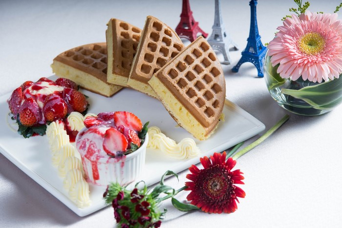Waffles with strawberries, ice cream, and Eiffel Tower miniatures
