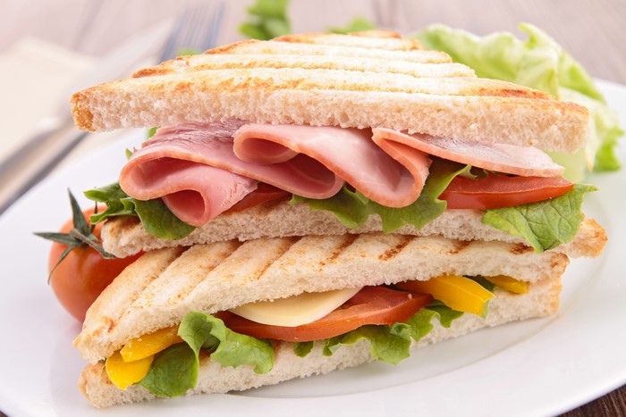 Toasted sandwich with ham, cheese, tomato, and lettuce