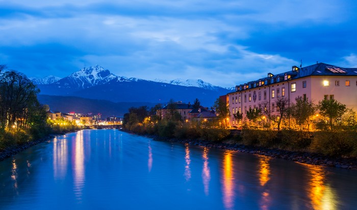 Innsbruck cityscape with river and mountains at night
