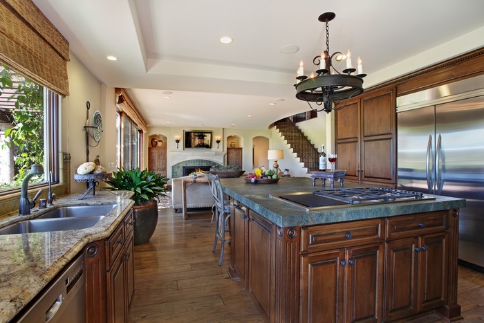 Kitchen with island, fireplace, and staircase