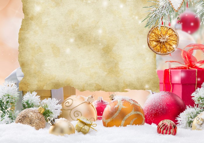 Christmas ornaments and gifts on snow with parchment