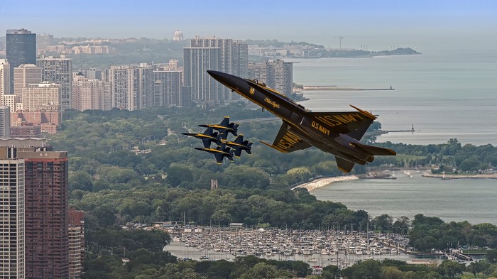 Blue Angels fighter jets fly over Chicago skyline and marina
