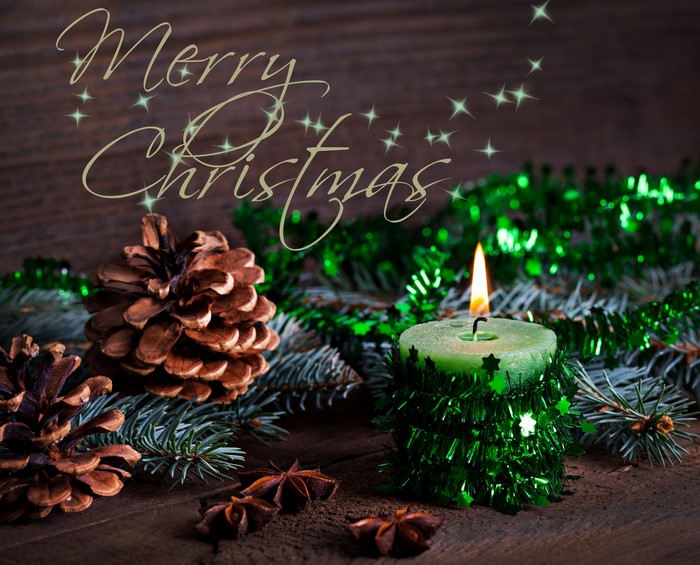 Merry Christmas candle with pine cones and tinsel