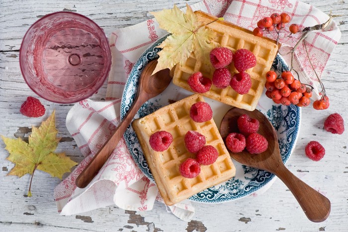 Still-life of waffles with raspberries and autumn leaves