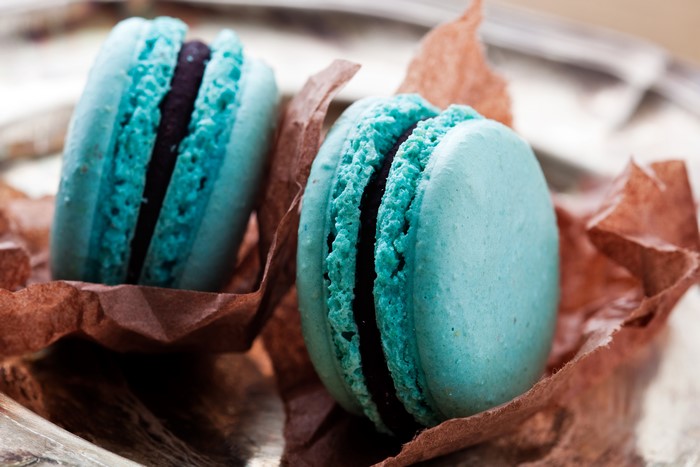 Two blue macarons with dark filling