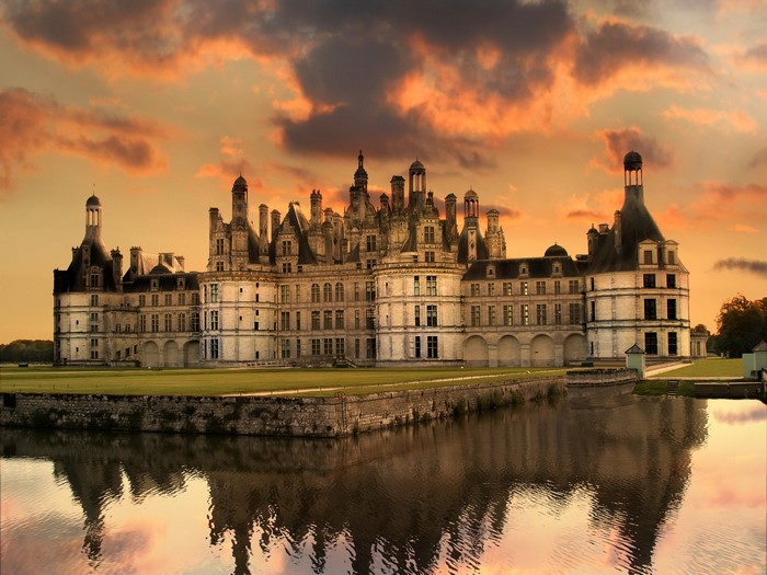 Chateau de Chambord reflected in water at sunset