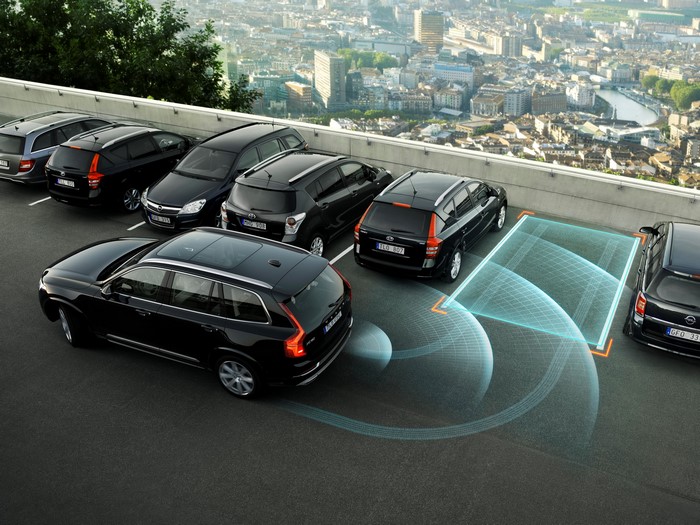 Black Volvo XC90 cars parked on a rooftop with city view