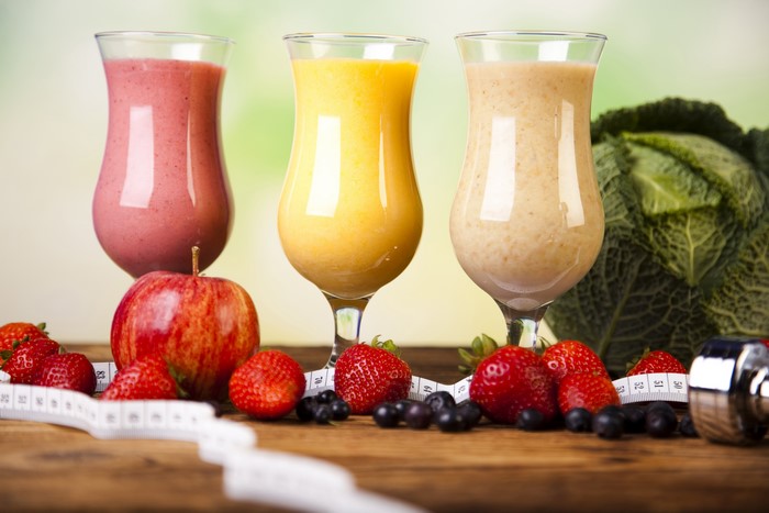 Three Smoothies with Fruits and Dumbbell