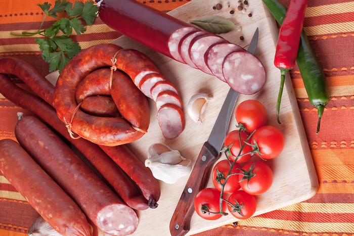 Sausages, Tomatoes, Peppers, and Garlic on Cutting Board
