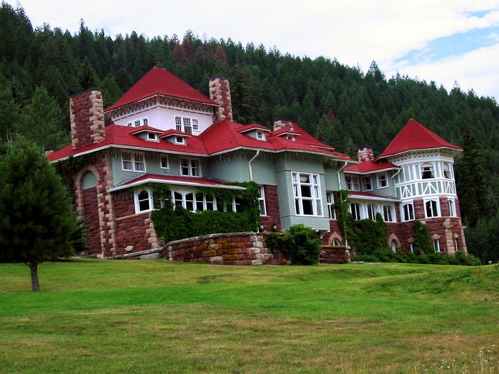 Large historic house with red roof and green siding