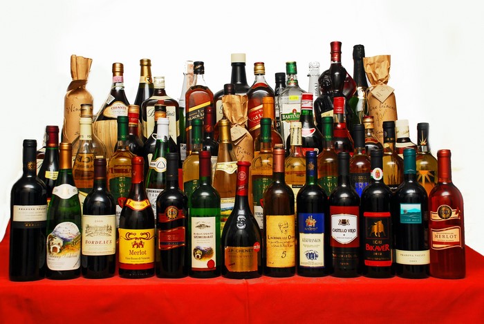 Collection of wine and liquor bottles on a red surface