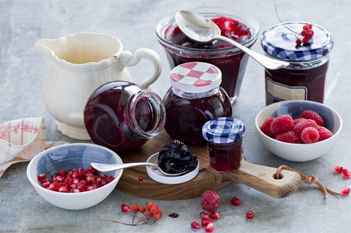 Jars of jam with raspberries and pomegranates